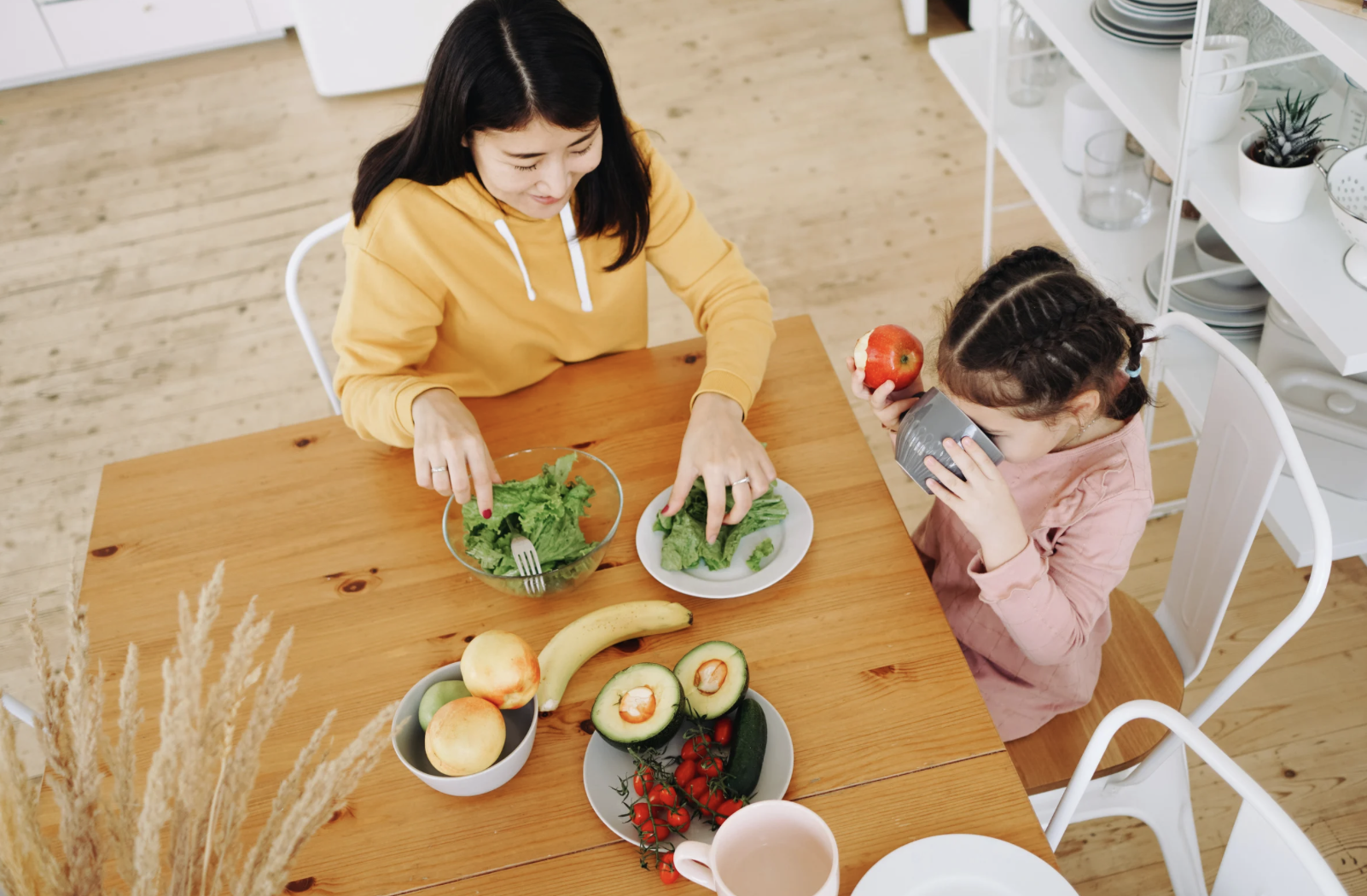 Mother and daughter eating at dining table.